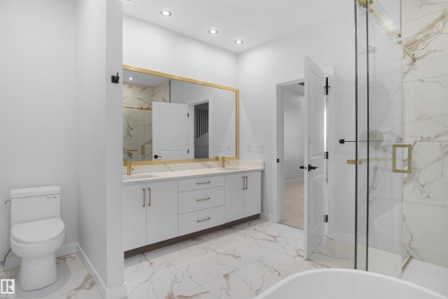 Contemporary bathroom featuring a double vanity with white cabinetry, gold hardware, and a quartz countertop - 6403 29 Ave, Edmonton, AB - Indoor Photo Showing Bathroom