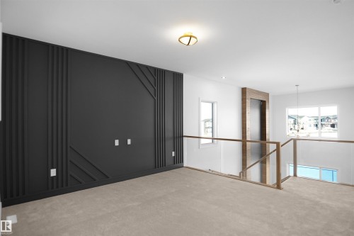 Accent wall featuring geometric paneling, plush carpeting, modern ceiling light fixture, expansive windows, and glass railing with wood-finish top - 6403 29 Ave, Edmonton, AB - Indoor Photo Showing Other Room