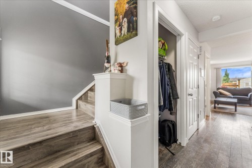 Staircase with wood-finish treads and risers, complemented by a white handrail and trim - 2324 30 Avenue, Edmonton, AB 