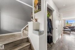 Staircase with wood-finish treads and risers, complemented by a white handrail and trim - 