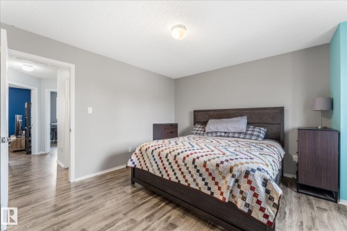Spacious bedroom featuring wood-finish flooring, light grey painted walls, and a light-colored ceiling - 2324 30 Avenue, Edmonton, AB 