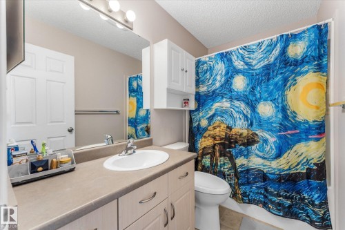 Bathroom featuring a single vanity with a laminate countertop, undermount sink, and chrome faucet - 2324 30 Avenue, Edmonton, AB 
