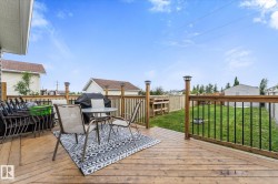 Spacious wood-finish deck with black metal balusters and post-mounted lighting - 