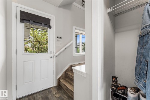 Entryway featuring a white door with a window, wood-finish flooring, and a built-in closet with shelving - 2324 30 Avenue, Edmonton, AB 