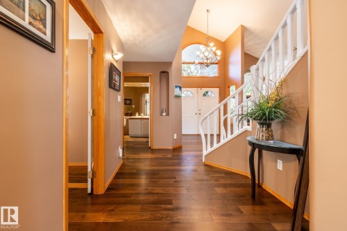 Vaulted entryway featuring wood-finish flooring and a white staircase with balusters - 315 Osland Place, Edmonton, AB 