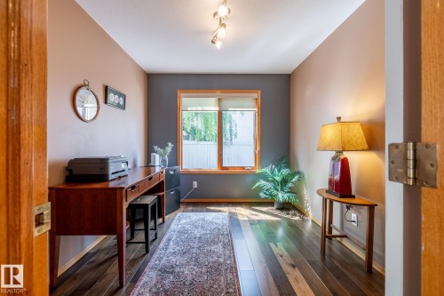 Interior space featuring wood-finish flooring, a wood-trimmed window, track lighting, and a neutral color palette - 315 Osland Place, Edmonton, AB 