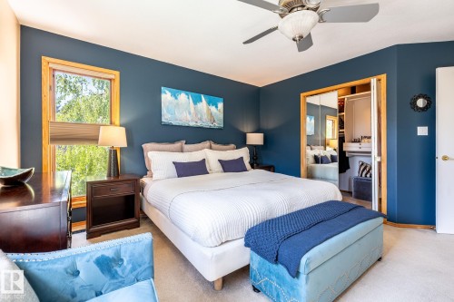 Bedroom featuring wood-finish window trim, a ceiling fan with integrated lighting, and a closet with mirrored bi-fold doors - 315 Osland Place, Edmonton, AB 