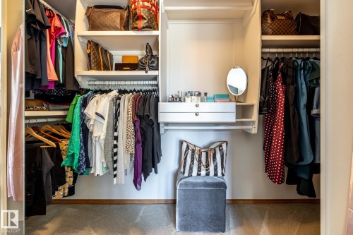 Custom closet system featuring built-in shelving, multiple hanging rods, and integrated drawers - 315 Osland Place, Edmonton, AB 