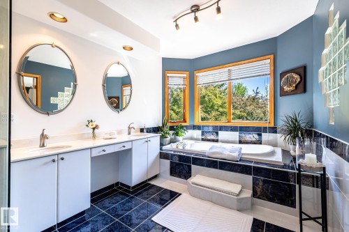Spacious bathroom featuring a built-in soaking tub, dual vanity with undermount sinks, and ample natural light through multiple windows - 315 Osland Place, Edmonton, AB 