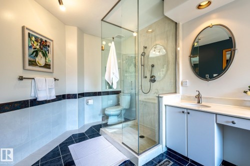 Glass-enclosed shower with a handheld showerhead and built-in bench - 315 Osland Place, Edmonton, AB 