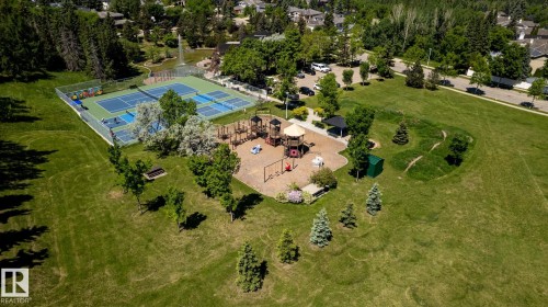 Expansive green space featuring multiple tennis courts, a playground with various structures, and mature trees - 315 Osland Place, Edmonton, AB 