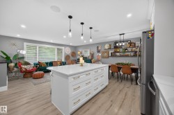 Central kitchen island with white cabinetry and gold-tone hardware - 