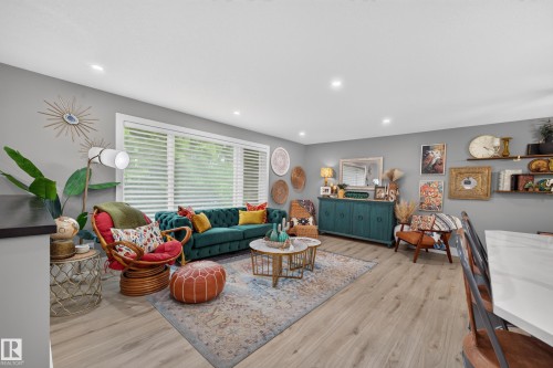 Spacious living area featuring wood-finish flooring, recessed lighting, and a large picture window with privacy blinds - 43 Burnham Place, St. Albert, AB 