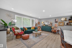 Spacious living area featuring wood-finish flooring, recessed lighting, and a large picture window with privacy blinds - 