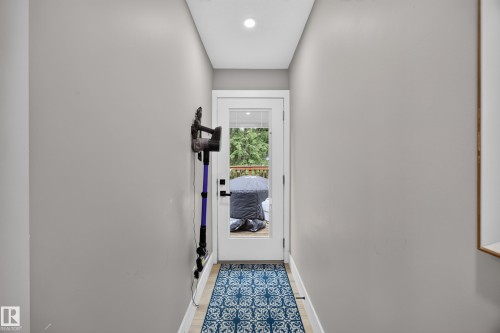 Hallway with light gray walls and wood-finish flooring - 43 Burnham Place, St. Albert, AB 