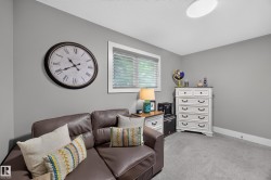 Carpeted room featuring a window with blinds, ceiling light fixture, and neutral gray walls - 
