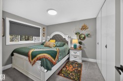 Carpeted bedroom featuring a large window with privacy blinds, recessed lighting, and built-in closet storage with modern flat-panel doors - 