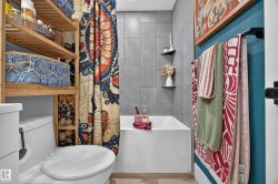 White bathtub with a gray tiled surround and built-in shelving - 