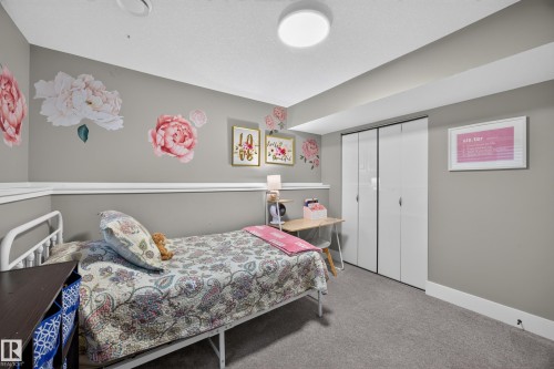 Carpeted interior with gray walls, white trim, and a built-in closet with bi-fold doors - 43 Burnham Place, St. Albert, AB 