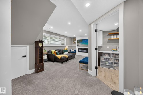 Carpeted recreation room with recessed lighting and a built-in electric fireplace - 43 Burnham Place, St. Albert, AB 