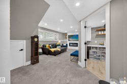 Carpeted recreation room with recessed lighting and a built-in electric fireplace - 