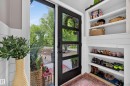 Entryway featuring a black-framed glass panel door, built-in shelving, white shiplap wall accents, and light wood-finish flooring - 43 Burnham Place, St. Albert, AB 