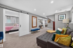 Carpeted entertainment space featuring recessed lighting and a sliding barn door entry to an additional room - 