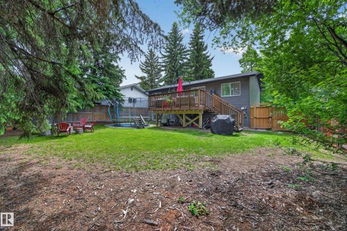 Expansive backyard featuring a manicured lawn, wood privacy fencing, and mature trees - 43 Burnham Place, St. Albert, AB 