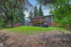 Expansive backyard featuring a manicured lawn, wood privacy fencing, and mature trees - 