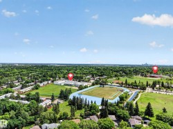 Aerial perspective showcasing a broad expanse of green space and mature tree canopy - 
