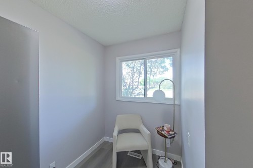 Light-filled alcove featuring a white-framed window, pale gray walls, and wood-finish flooring - 176 Centennial Court, Edmonton, AB 