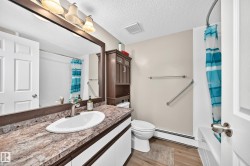 Bathroom featuring a vanity with an oval sink, brushed nickel faucet, and a patterned countertop - 