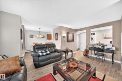 Open-concept living space featuring wood-finish flooring and neutral-toned walls - 