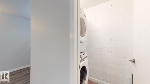 Integrated stackable washer and dryer appliances within a dedicated laundry alcove - 11744 135 Street, Edmonton, AB - Indoor Photo Showing Laundry Room