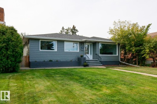 Exterior featuring dark gray horizontal siding with white trim, a gray shingled roof, and a dark gray brick foundation - 11744 135 Street, Edmonton, AB - Outdoor