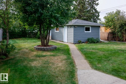 Detached garage with horizontal siding, white trim windows, and a dark shingle roof - 11744 135 Street, Edmonton, AB - Outdoor