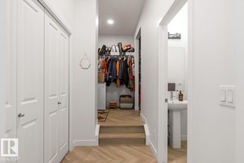 Hallway featuring wood-finish flooring with a herringbone pattern, white walls, and recessed lighting - 117 Paisley Gate Gate, Edmonton, AB 