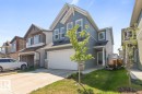 Contemporary two-story residence featuring blue horizontal siding, white trim, a stone accent column, and an attached two-car garage - 117 Paisley Gate Gate, Edmonton, AB 