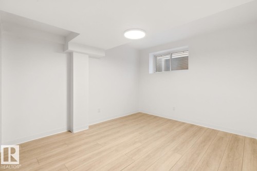Bright room featuring wood-finish flooring, white walls, and a contemporary flush-mount ceiling light - 117 Paisley Gate Gate, Edmonton, AB 