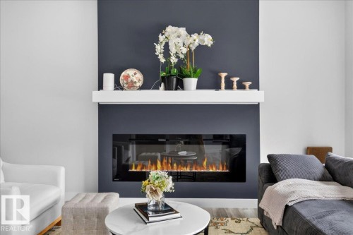 Built-in fireplace feature with a dark accent wall, white mantel, and integrated electric fireplace insert - 424 Black Stone Link, Leduc, AB 