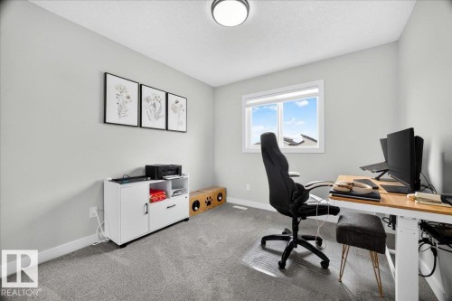 Carpeted room with a single window, light gray walls, and a flush-mount ceiling light - 424 Black Stone Link, Leduc, AB 