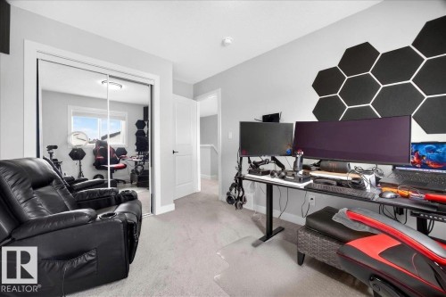 Carpeted room featuring a white door, light grey walls, and a mirrored closet with sliding doors - 424 Black Stone Link, Leduc, AB 