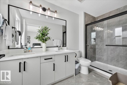 Double vanity with white countertops, undermount sinks, and light gray cabinetry - 424 Black Stone Link, Leduc, AB 
