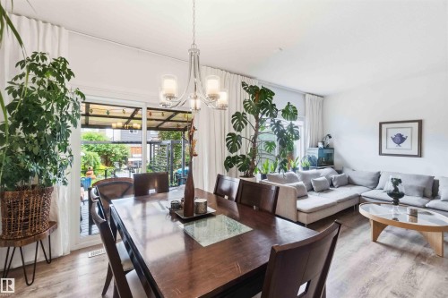 Open-concept living space with wood-finish flooring, white walls, and bright natural light - 9323 223 Street, Edmonton, AB 