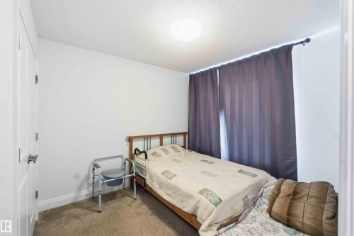 Bedroom featuring neutral carpeting and white wall paint - 9323 223 Street, Edmonton, AB 