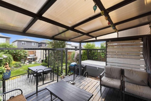 Expansive outdoor living area featuring a covered deck, wood-finish flooring, and a privacy screen - 9323 223 Street, Edmonton, AB 