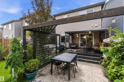 Outdoor patio featuring flagstone pavers, a dark wood pergola, and a privacy screen - 9323 223 Street, Edmonton, AB 