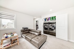 Dedicated laundry closet featuring a stackable washer and dryer set, integrated shelving, and white bi-fold doors - 