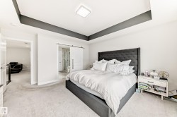 Recessed ceiling with contrasting dark accent, light-toned carpeting, and a modern square flush-mount light fixture - 