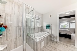 Contemporary bathroom featuring a jetted tub, a separate shower with a glass enclosure, and large format tile flooring - 